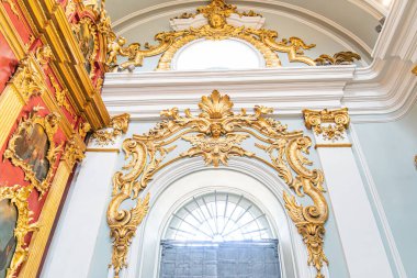 Altın tavan, dekoratif desenler, kırmızı duvarlar, St Andrews Kilisesi iç mimarisi, kemerli bir pencereden geçen doğal ışık, renk ve tarzların uyumlu karışımı, büyük oda, Kyiv, Ukrayna 06-20-2025