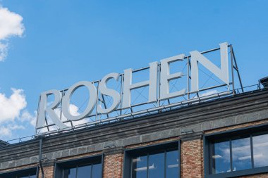 Tarihi bölge sokak manzarası, şekerleme fabrikası Roshen, tuğla fabrikası binaları, geniş pencere kapıları, kırmızı ve siyah renkler, ROSHEN tabelaları, kaldırım Kyiv, Ukrayna 07-13-2025