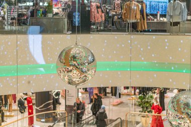 Gece vakti mağaza girişi ışıl ışıl parlayan mankenler modaya uygun kıyafetler sergiliyor, askıya alınmış metalik ışıklar dinamik ışıklı Kyiv, Ukrayna 12-24-2023