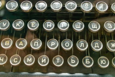 Görünür tuşlara sahip klasik metal daktilo, Latin alfabesi, sayılar, semboller, bulanık arkaplana karşı seçici bir odak