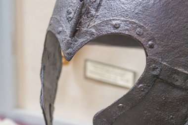 Paslı, eski ya da yıpranmış miğfer, kenarı yükseltilmiş, müze dekorasyonu, cam vitrin, etiket, yumuşak gölgeler, doku. a