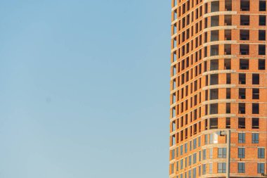 Modern, düzensiz şekilli pencereler, balkonlar, toprak renkleri, bulutlu gökyüzü, dağınık ışıklandırma, soyut mimari, sessiz renkler, mimari yakalama dikey çizgiler