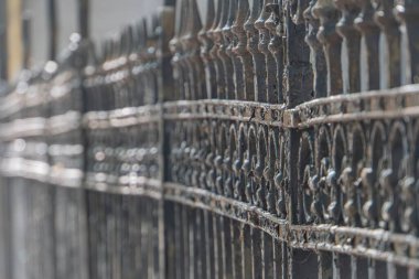 Eski, paslı demir çit panel yakın plan kentsel arkaplan karşı, sağ taraftan ışıklandırma