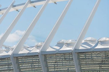 Modern mimari yapı, kafes veya kafes tasarımı, geometrik desen, ızgara benzeri çerçeve, cam elementler, beyaz renk şeması, açık hava düzeni, parlak ışıklandırma, yumuşak gölgeler, açılı perspektif