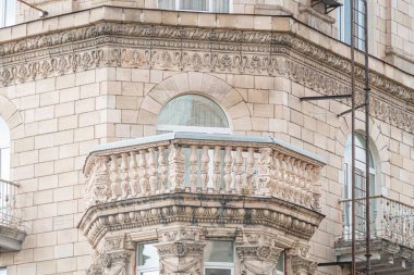 Çoğunlukla toprak tonlarında oyulmuş elementlerle dolu karmaşık, tarihi bir Avrupa bina cephesine yakın plan.