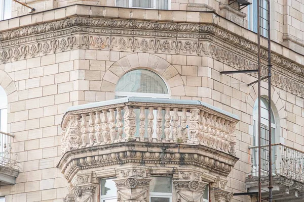 Çoğunlukla toprak tonlarında oyulmuş elementlerle dolu karmaşık, tarihi bir Avrupa bina cephesine yakın plan.