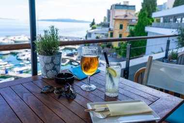 Hırvatistan 'da balkondan deniz manzaralı içecek içmek.