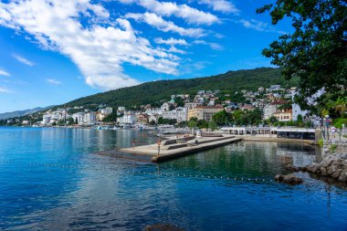 Opatija, Hırvatistan - 08.25.2025: Adriyatik Denizi, Lungomare gezinti güvertesi ve kıyı kenti ile Opatija Hırvatistan 'ın manzarası .