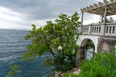 Stone seaside path Lungomare with railing along Adriatic coast in Opatija, Croatia .