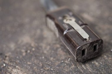 Endüstriyel bir yüzeyde eski bir vintage elektrik konnektörünün yakın çekimi, retro teknoloji, onarım, atölye ve mühendislik temalı kavramlar için ideal.