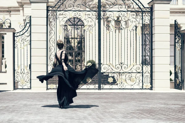 Mujer en un retrato al aire libre vestido negro. Estilo clásico vintage. Le dispararon por la espalda. fondo vintage —  Fotos de Stock