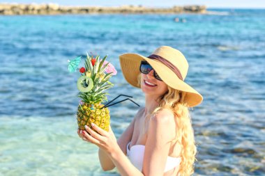 Plajda ananas kokteyli. Mutlu kız taze sulu kokteyl içme. Ayia Napa, Kıbrıs