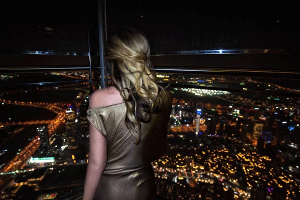 Mujer en la azotea Dubai, Emiratos Árabes Unidos. Vista panorámica de la ciudad por las noches — Foto de Stock
