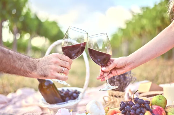 Mãos de homem e mulher com dois copos de torrada de vinho no piquenique ao ar livre. Lindos fundos de verão — Fotografia de Stock