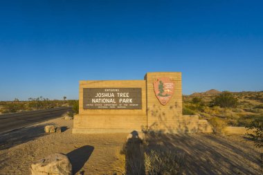Gün batımında, Kaliforniya 'da Joshua Tree Ulusal Parkı tabelası. Günbatımında, Kaliforniya, ABD.