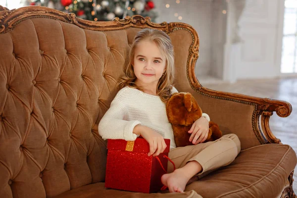 Petite Fille Étreint Cadeau Sur Fond Arbre Noël — Photo
