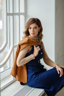 Denim sundress çekici bir güzel kız portresi oturmak