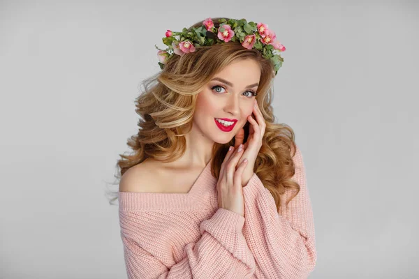 Schöne blonde Mädchen mit einem Blumenkranz und rotem Lippenstift — Stockfoto