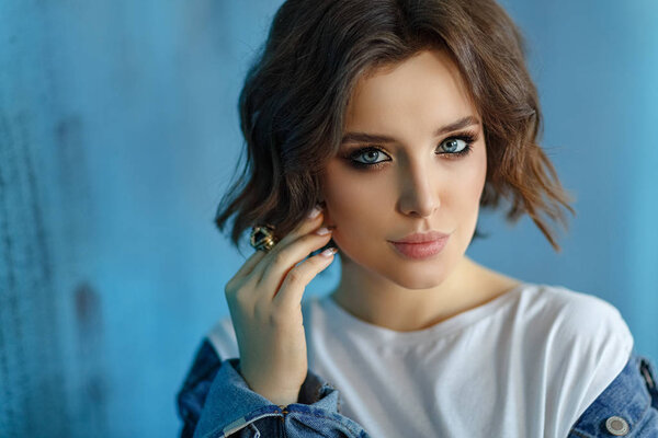Sexy beautiful model brunette girl with blue eyes in blue denim.