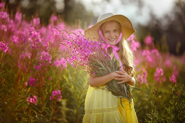 Een klein meisje in een gele jurk en muts, holding lila bloemen ik — Stockfoto