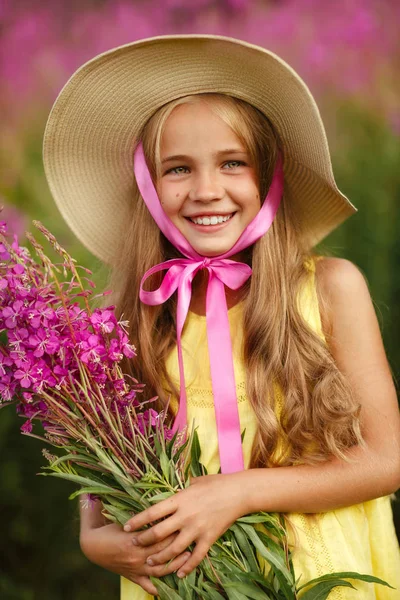 Dziewczynka w żółty strój i kapelusz, trzymając liliowy kwiatki i — Zdjęcie stockowe
