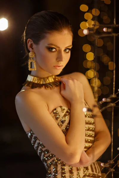 Retrato de uma bela menina sexy com maquiagem em um vestido de ouro em — Fotografia de Stock