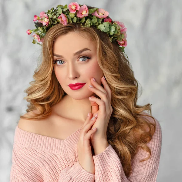 Schöne, helle Blondine lächelt, auf ihrem Kopf ein Kranz aus Blumen — Stockfoto