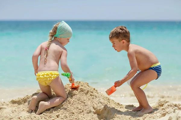 Niña bonita y niño de 4 años jugando con arena y wate Fotos De Stock