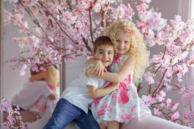 Sevimli sevimli küçük çocuk ve sarışın kız sarılma vardır, ağa