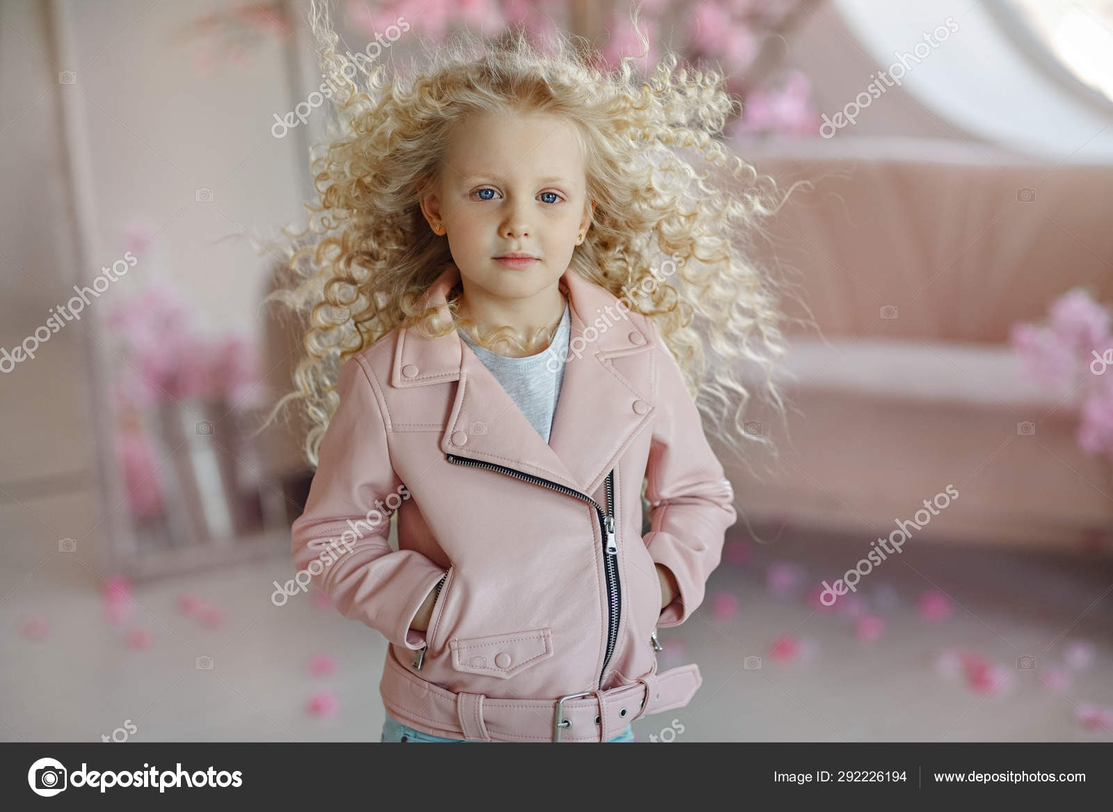 Little Pretty Girl Curly Blonde With Blue Eyes In A Pink Jacket