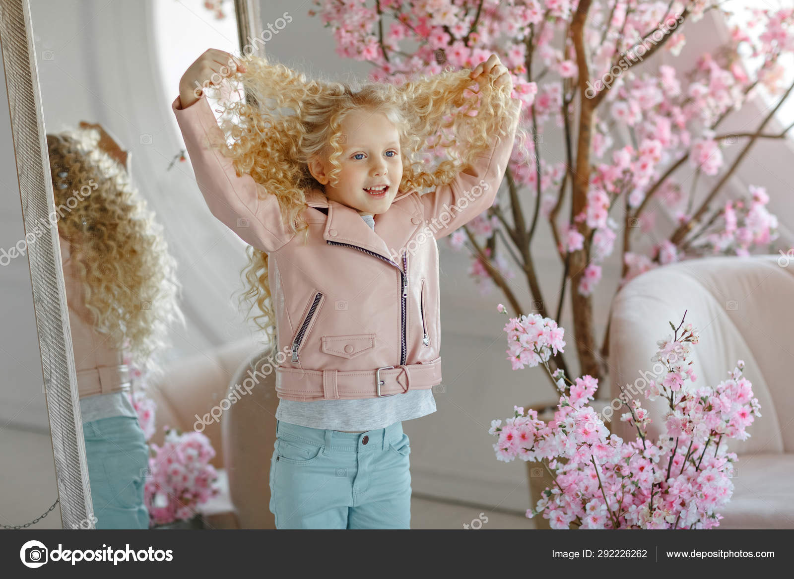 Little Pretty Girl Curly Blonde With Blue Eyes Stands At The M