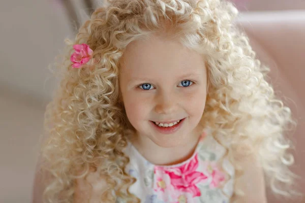 Pequeña chica rubia rizada muy linda con ojos azules en un dres rosa —  Fotos de Stock