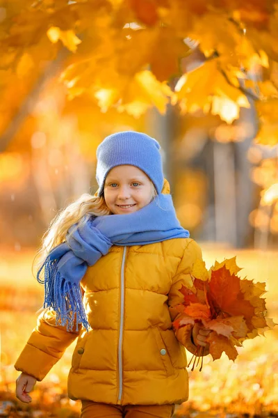 Frumos fetiță blondă cu ochi albaștri într-o jachetă galbenă s — Fotografie, imagine de stoc