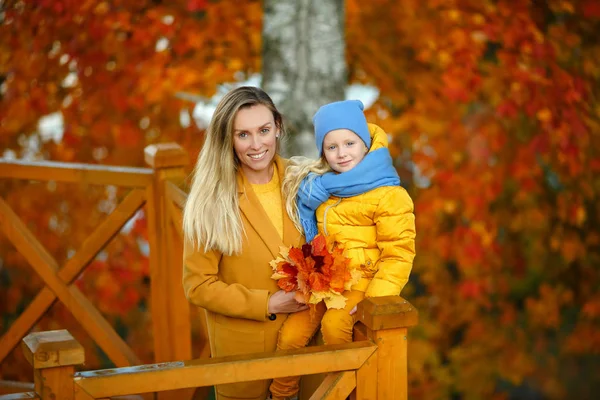 Мама і дочка блондинки з блакитними очима в жовтому і синьому с. — стокове фото