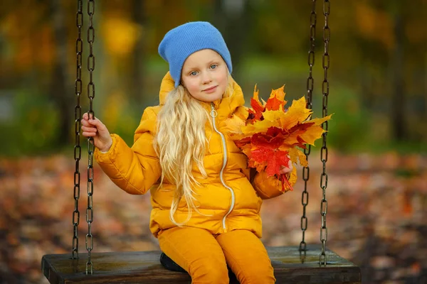 Frumos fetiță blondă cu ochi albaștri, într-o jachetă galbenă — Fotografie, imagine de stoc
