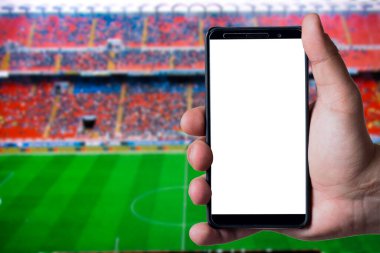 Futbol ya da futbol stadyumunun arka planında akıllı telefon tutan adamlar. Model sunumu için beyaz boş ekran hazır.