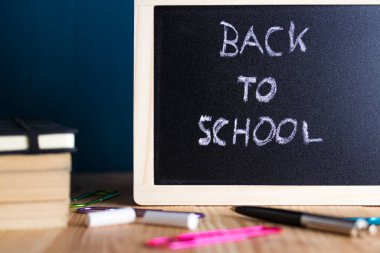 Kitap, kalem, ataç ve tebeşirle karatahtaya yazılmış okula geri döndüm..