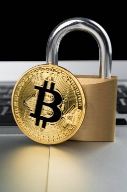 Bilgisayar klavyesinde asma kilit olan fiziksel bitcoin. Siber kripto para birimi güvenlik soyut kavramı. Dikey yönelim.