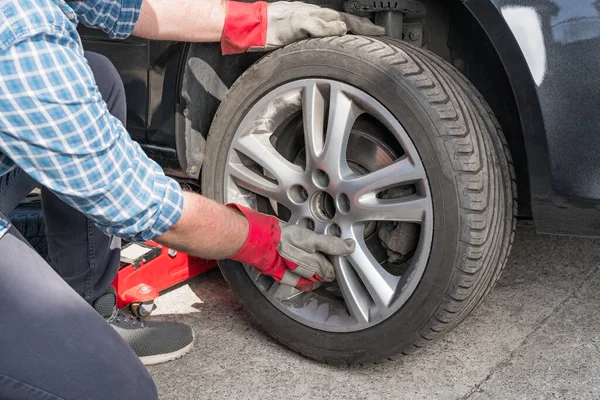 Man Sätter Eller Skruvar Ett Bilhjul Säsongsvis Däckbyte Eller Tjänsteabstrakt — Stockfoto