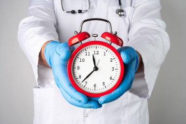 Beyaz bir adam koruyucu eldivenlerle elinde antika kırmızı çalar saat tutan bir tıp doktoru kılığında. Karantina ya da salgın soyut kavramı bitirme zamanı..