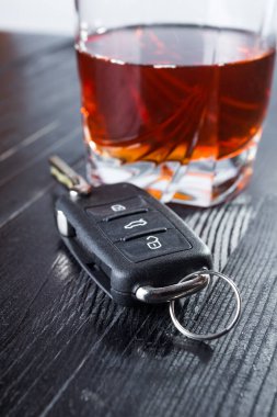 Araba anahtarı ve viski, siyah ahşap masada bir bardakta içki. Alkollü araç kullanma ve soyut kavram kullanma..