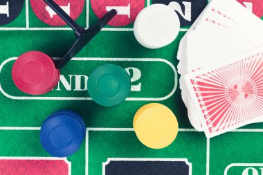 Kumarhane fişleri ve yeşil masada yığınla kağıt. Kumar problemleri soyut bir kavram. Eski renkler.