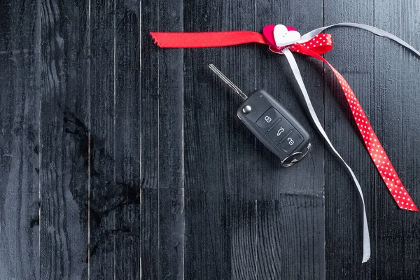 Cark Key Red Ribbon Adn Heart Black Wooden Table Giving — Stock Photo, Image