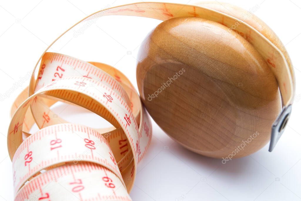 Yo-yo effect in diet concept. Wooden yoyo with centimeter measure. Closeup. Isolated on white background.