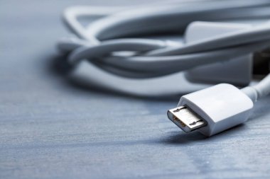 Mikro usb akıllı telefon güç kablosunun ahşap bir arka planda yakınlaştırılması.