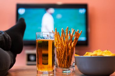 Futbol ya da televizyonda bira, cips ve ekmek çubuklarıyla futbol izlemek..