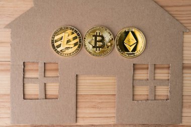Fiziksel Bitcoin, Litecoin ve Ethereum paralarıyla ev yapımı. Kripto para birimi ve emlak piyasası.
