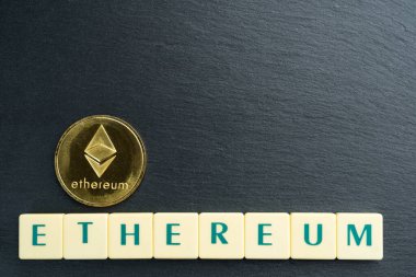 Harf karolarından yapılmış yazılı fiziksel Ethereum altın sikkesi. Kripto para birimi. Boşluğu üste kopyala.