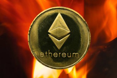 Fiziksel Ethereum altın sikkesi (ETH) ateş ya da alev zeminli. Artan fiyatlarla kripto para birimi boğa piyasası büyümesi.