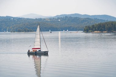 Solina, Polonya - 24 Haziran 2019: Yelkenli Solina Barajı yakınlarındaki yapay bir gölde yüzüyor.